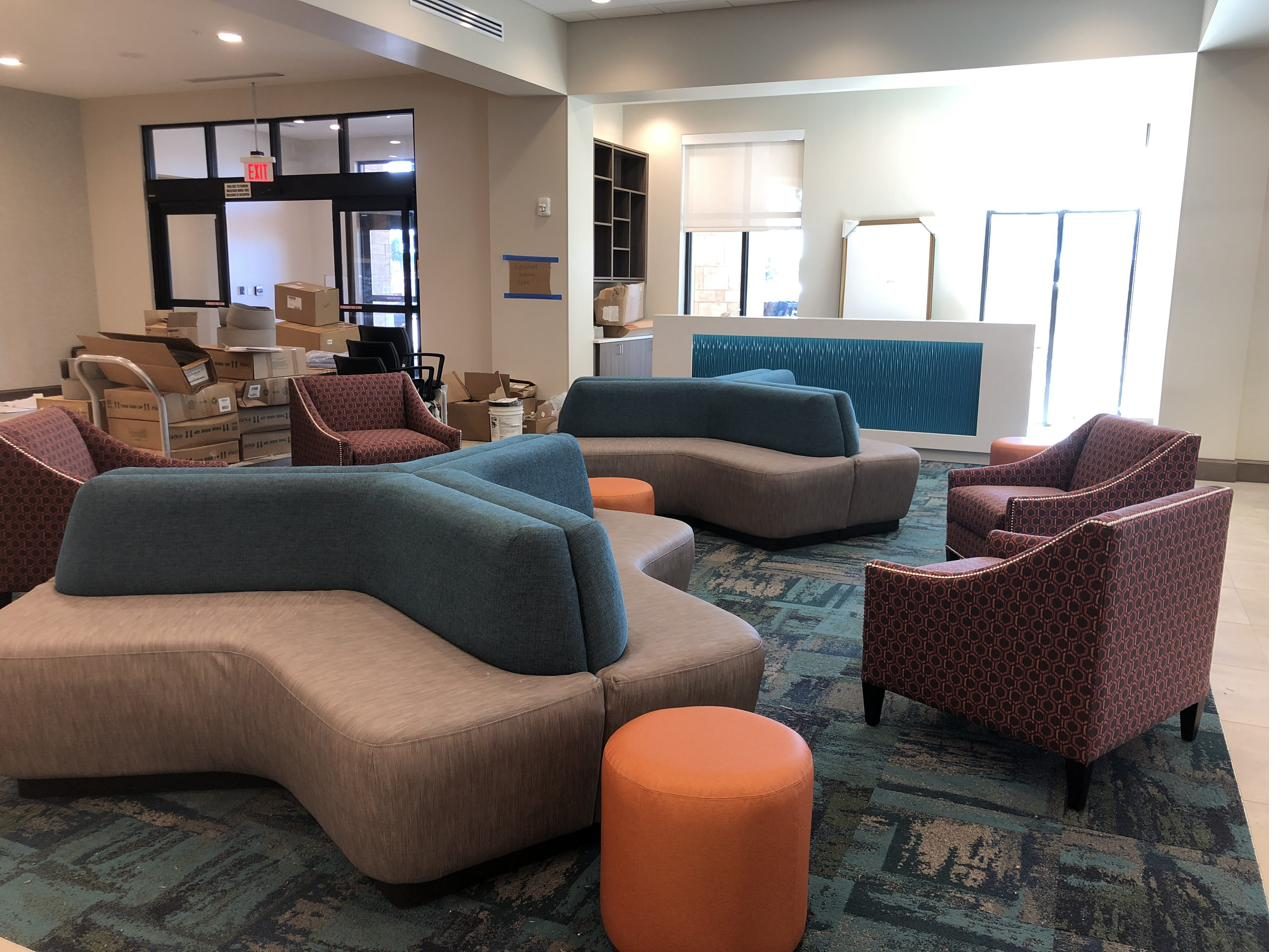 Completed hotel lobby with curved sectional sofas and patterned area rug