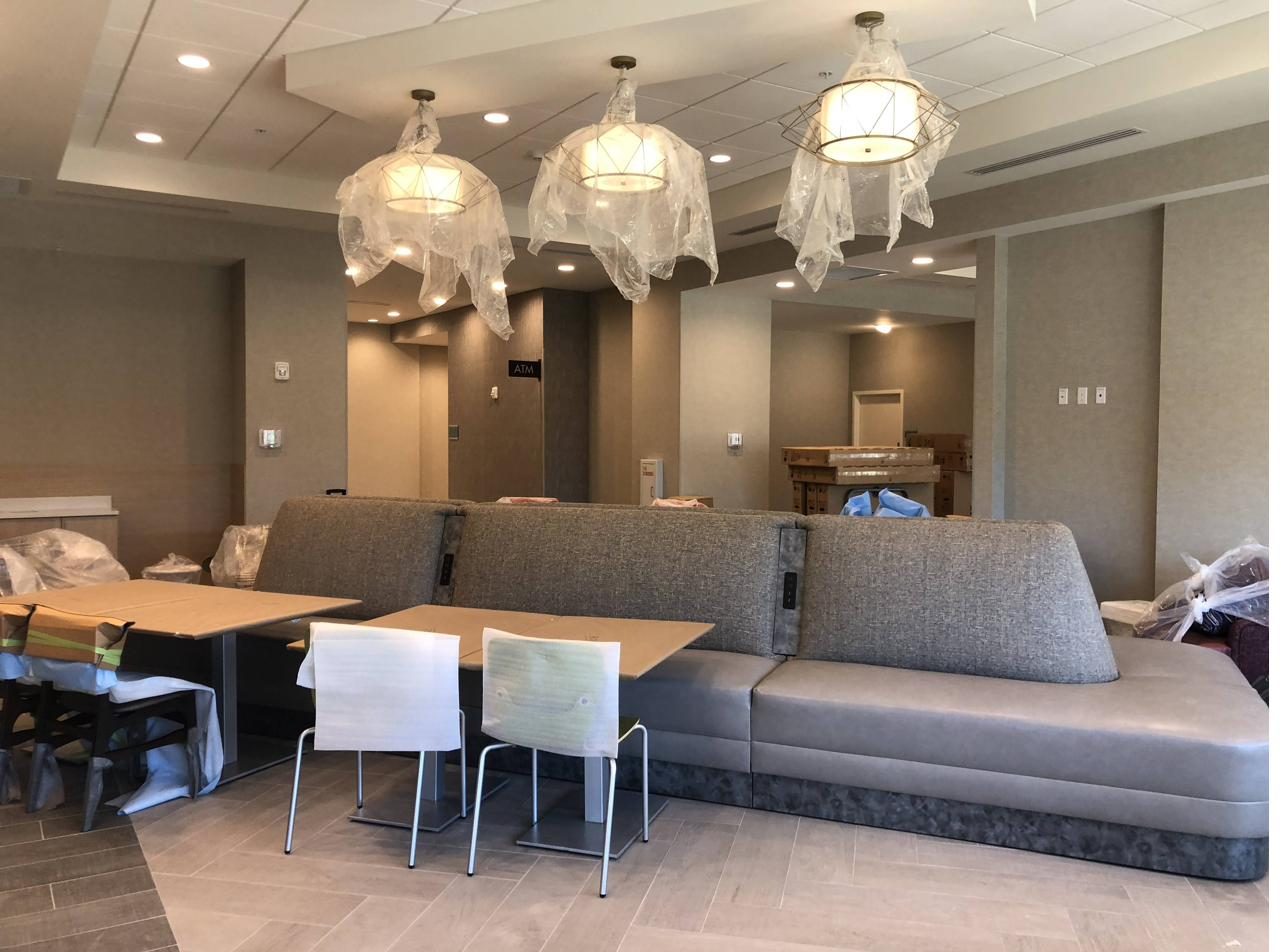 Hotel breakfast nook with installed banquette seating and pendant lighting still wrapped